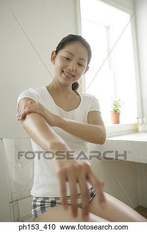 Young woman applying moisturizer on her hand in the bathroom View Large Photo Image Stock Image - Young woman applying moisturizer on her hand in the bathroom. Fotosearch