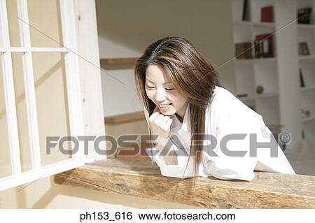 Young woman bending over a window View Large Photo Image Stock Photograph - Young woman bending over a window. Fotosearch