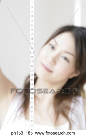 Young woman holding a tape measure View Large Photo Image Stock Photography - Young woman holding a tape measure. Fotosearch