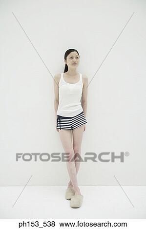 Stock Photo - Young woman leaning against a wall. Fotosearch