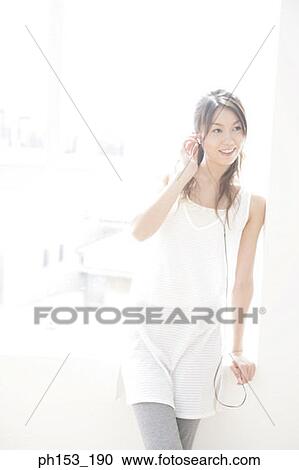 Young woman leaning against a window and listening to music View Large Photo Image Stock Image - Young woman leaning against a window and listening to music. Fotosearch