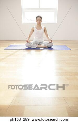 Young woman meditating on an exercise mat View Large Photo Image Stock Photo - Young woman meditating on an exercise mat. Fotosearch
