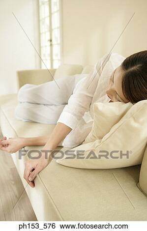 Young woman sleeping on a couch View Large Photo Image Stock Photograph - Young woman sleeping on a couch. Fotosearch