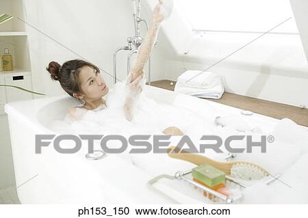 Young woman soaking in a bubble bath View Large Photo Image Stock Image - Young woman soaking in a bubble bath. Fotosearch