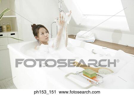 Young woman soaking in a bubble bath View Large Photo Image Stock Image - Young woman soaking in a bubble bath. Fotosearch
