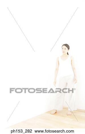Young woman standing at the corner of a room View Large Photo Image Stock Image - Young woman standing at the corner of a room. Fotosearch