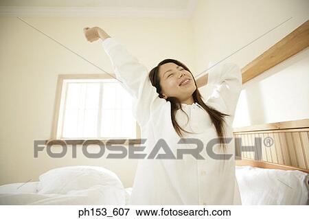 Stock Photo - Young woman stretching her arms. Fotosearch