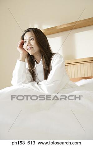 Stock Image - Young woman thinking with her head in her hands. Fotosearch