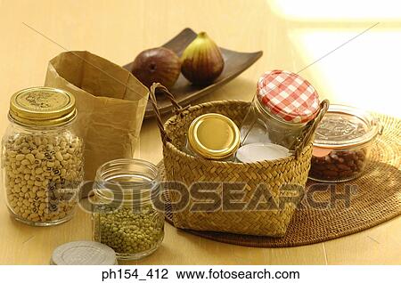 Stock Image - Beans in jars with a wicker basket of empty jars on the table. Fotosearch