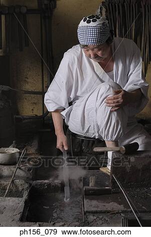 Blacksmith dipping a heated metal rod into water View Large Photo Image Stock Photo - Blacksmith dipping a heated metal rod into water. Fotosearch