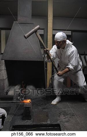 Blacksmith hitting a heated metal rod with a hammer View Large Photo Image Stock Photograph - Blacksmith hitting a heated metal rod with a hammer. Fotosearch