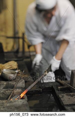 Blacksmith holding a heated metal rod View Large Photo Image Stock Image - Blacksmith holding a heated metal rod. Fotosearch