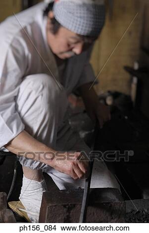 Blacksmith holding a metal rod View Large Photo Image Picture - Blacksmith holding a metal rod. Fotosearch