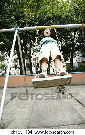 Picture - Boy sitting on a swing. Fotosearch