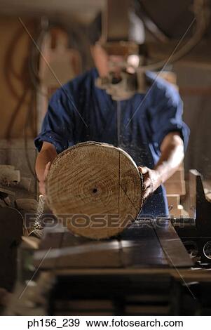 Carpenter holding wood in a workshop View Large Photo Image Stock Photo - Carpenter holding wood in a workshop. Fotosearch