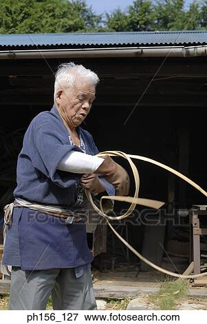 Stock Photo - Carpenter twisting cane into a ring. Fotosearch