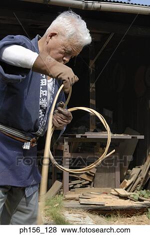 Stock Photo - Carpenter twisting cane into a ring. Fotosearch
