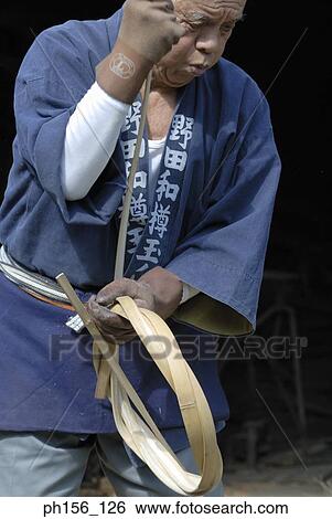 Stock Photograph - Carpenter twisting cane into a ring. Fotosearch