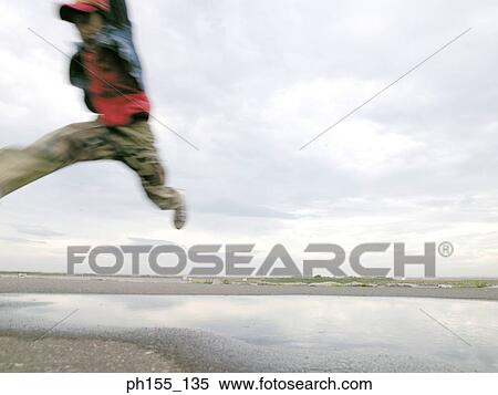 Child jumping over water View Large Photo Image Stock Photography - Child jumping over water. Fotosearch