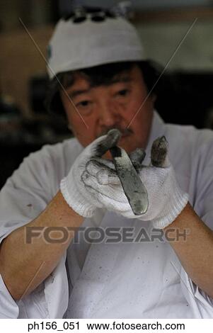 Close-up of a blacksmith examining a piece of metal View Large Photo Image Stock Image - Close-up of a blacksmith examining a piece of metal. Fotosearch