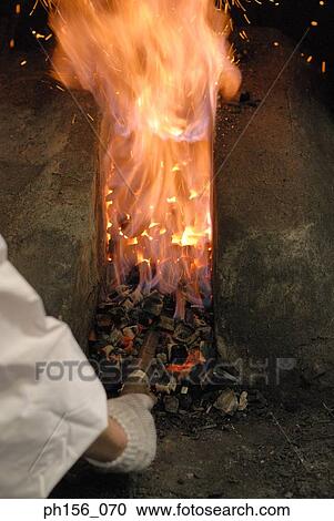 Close-up of a blacksmith's hand heating a metal rod in fire View Large Photo Image Stock Image - Close-up of a blacksmith's hand heating a metal rod in fire. Fotosearch