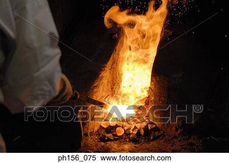Close-up of a blacksmith's hand heating a metal rod in fire View Large Photo Image Stock Photography - Close-up of a blacksmith's hand heating a metal rod in fire. Fotosearch