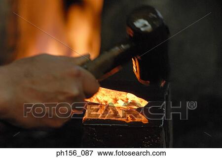 Close-up of a blacksmith's hand hitting a heated metal rod with a hammer View Large Photo Image Stock Photo - Close-up of a blacksmith's hand hitting a heated metal rod with a hammer. Fotosearch