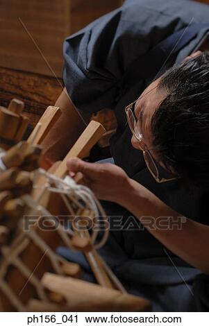 Stock Image - Close-up of a carpenter examining a samisen. Fotosearch