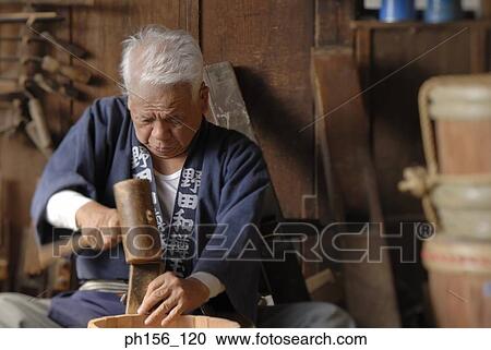 Stock Image - Close-up of a carpenter hammering wood. Fotosearch