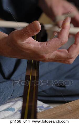 Picture - Close-up of a carpenter's hand making a samisen. Fotosearch