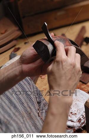 Stock Image - Close-up of a carpenter's hand peeling wood. Fotosearch