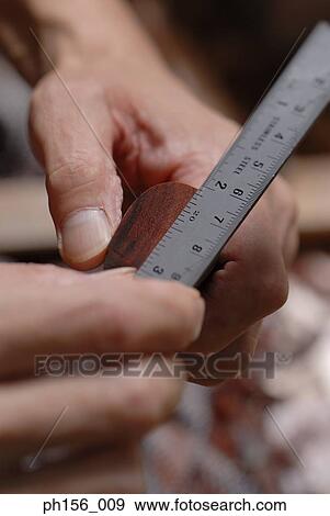 Close-up of a carpenter's hand using a ruler View Large Photo Image Stock Photo - Close-up of a carpenter's hand using a ruler. Fotosearch