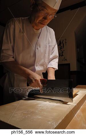 Stock Photograph - Close-up of a chef cutting noodles. Fotosearch