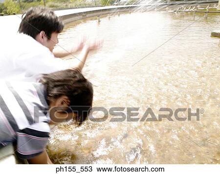 Close-up of a father and his son spraying water View Large Photo Image Stock Image - Close-up of a father and his son spraying water. Fotosearch