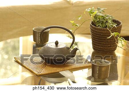 Stock Image - Close-up of a kettle with two cups on the table. Fotosearch