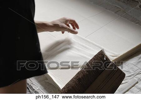 Stock Photo - Close-up of a man's hand over sheets of paper. Fotosearch
