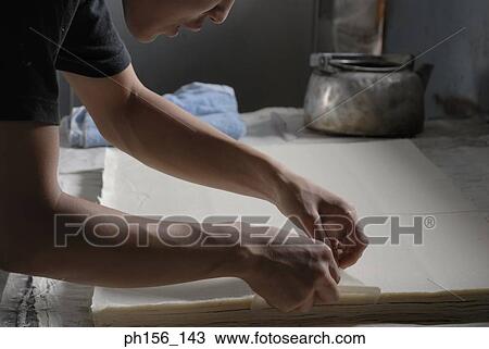 Close-up of a man's hands cutting sheets of paper with the help of a comb View Large Photo Image Stock Image - Close-up of a man's hands cutting sheets of paper with the help of a comb. Fotosearch