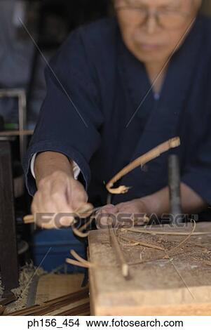 Close-up of a mature man shaving a wooden stick View Large Photo Image Picture - Close-up of a mature man shaving a wooden stick. Fotosearch