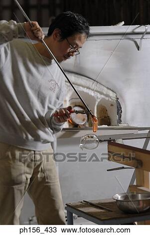 Close-up of a mid adult man holding a blow pipe View Large Photo Image Stock Image - Close-up of a mid adult man holding a blow pipe. Fotosearch
