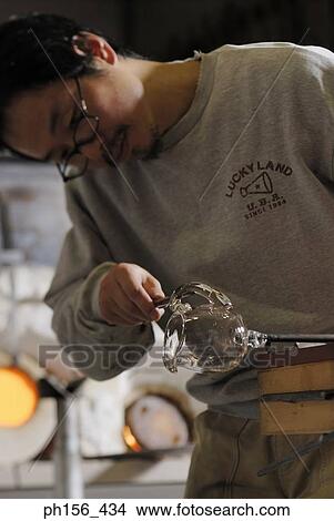 Close-up of a mid adult man molding a glass bulb View Large Photo Image Picture - Close-up of a mid adult man molding a glass bulb. Fotosearch