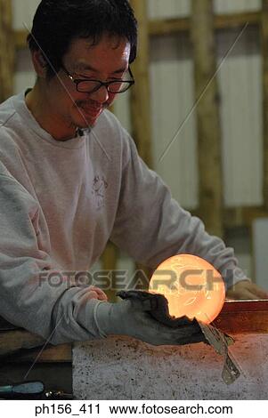 Close-up of a mid adult man molding a glass bulb View Large Photo Image Stock Image - Close-up of a mid adult man molding a glass bulb. Fotosearch