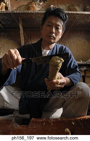 Stock Photo - Close-up of a mid adult man peeling a candle with a knife. Fotosearch