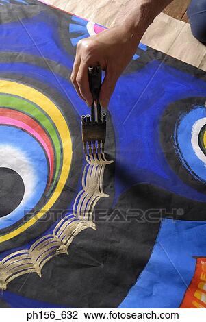 Stock Image - Close-up of a painter's hands painting on a sheet. Fotosearch