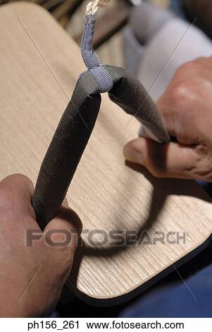 Stock Image - Close-up of a person holding a wooden piece. Fotosearch
