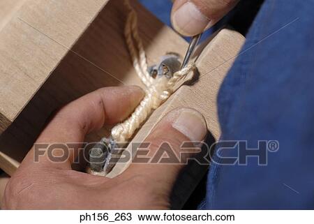 Stock Image - Close-up of a person using a needle. Fotosearch