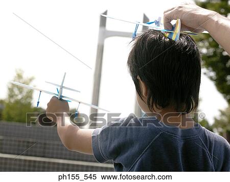 Close-up of a person's hand and a boy holding model airplanes View Large Photo Image Stock Photography - Close-up of a person's hand and a boy holding model airplanes. Fotosearch