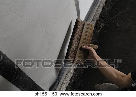 Stock Image - Close-up of a person's hand brushing on a sheet of paper. Fotosearch