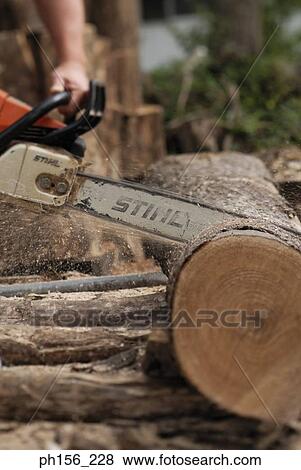 Close-up of a person's hand cutting logs with an electric saw View Large Photo Image Stock Photo - Close-up of a person's hand cutting logs with an electric saw. Fotosearch