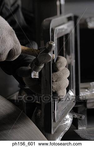 Stock Image - Close-up of a person's hand holding a hammer. Fotosearch