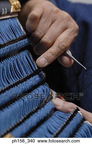 Close-up of a person's hand making a traditional costume View Large Photo Image Stock Image - Close-up of a person's hand making a traditional costume. Fotosearch